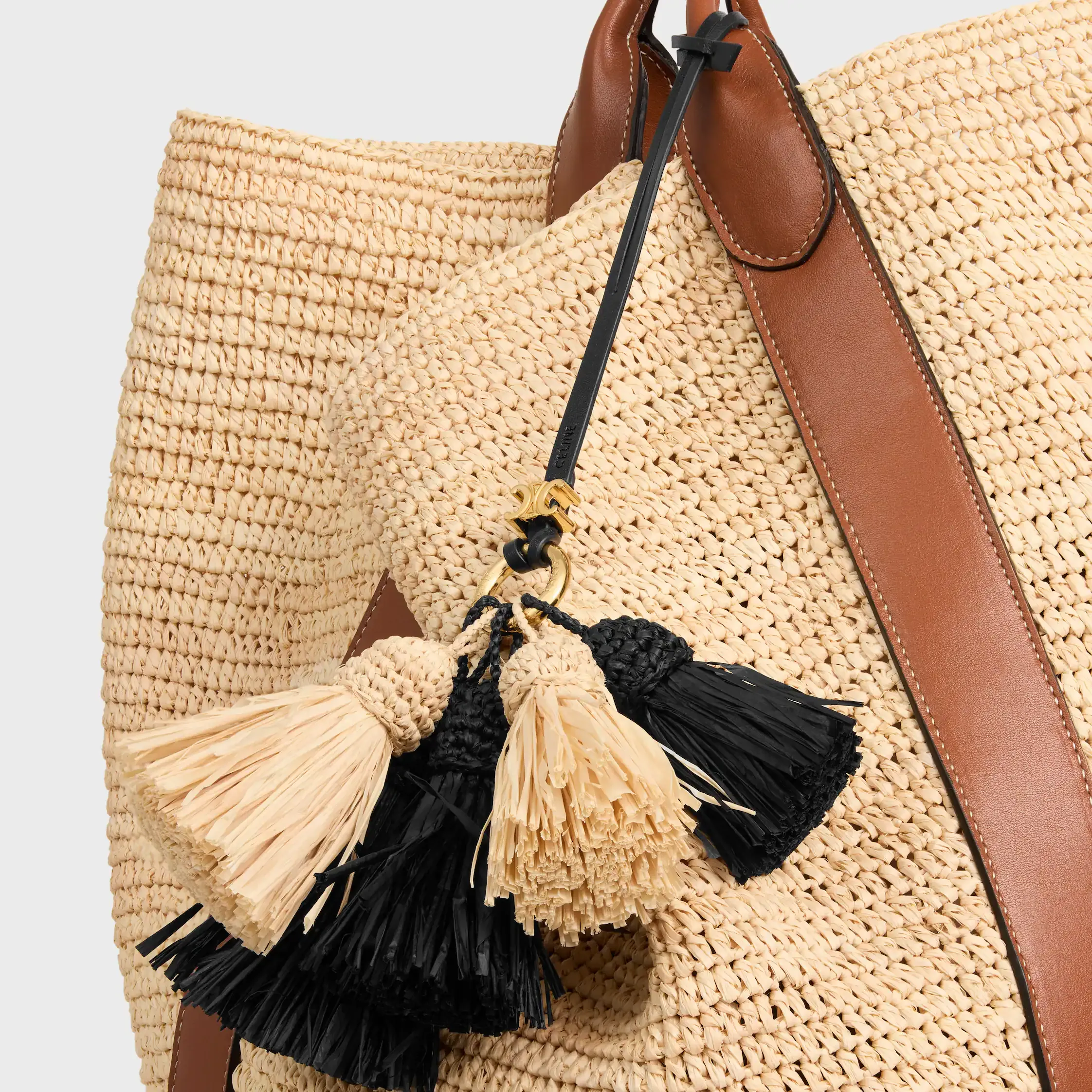 MULTI POMPON CHARM AUS RATTAN UND GLATTEM LAMMLEDER